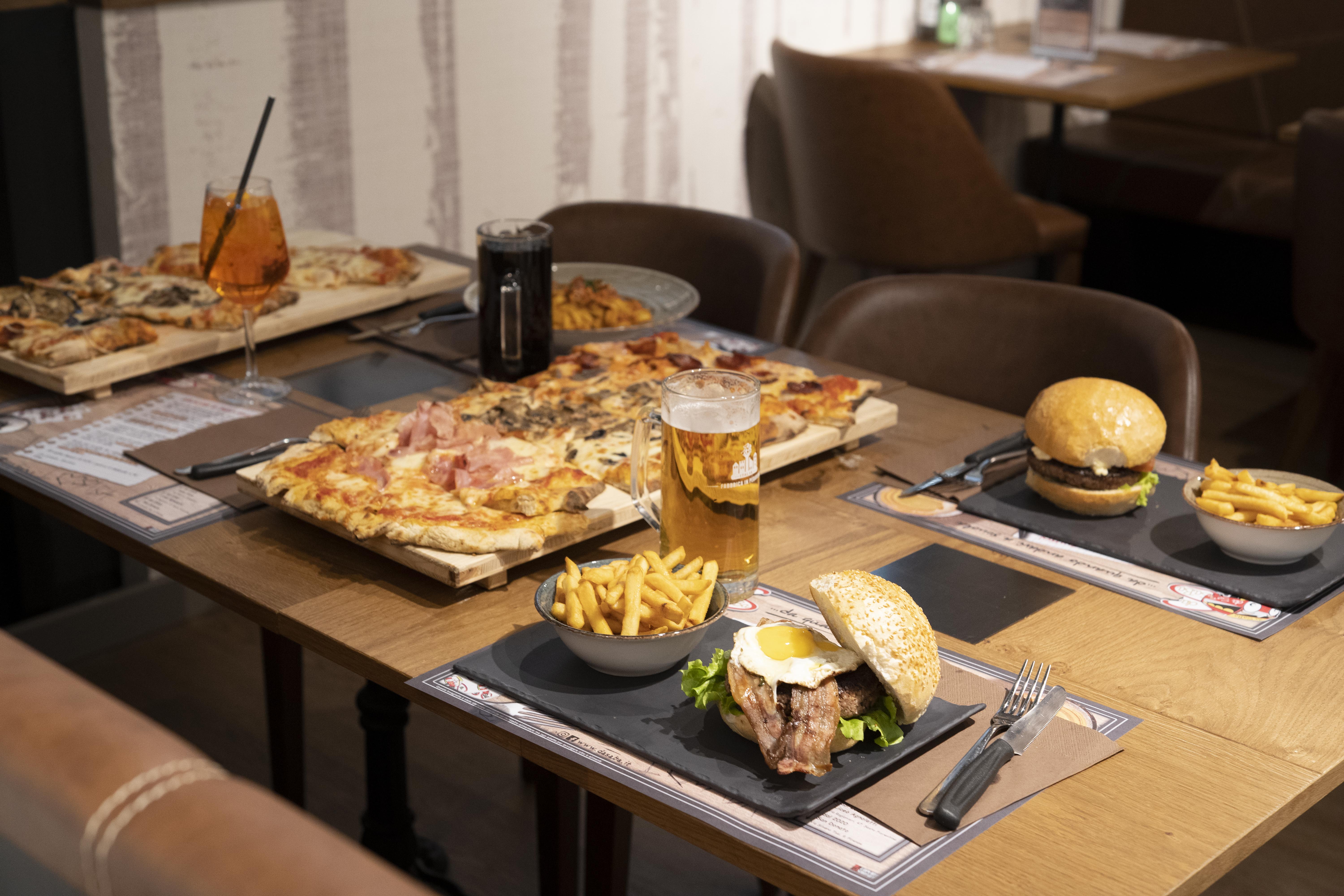 Tavola apparecchiata Da Saba I Gigli con pizza, panini e bevande